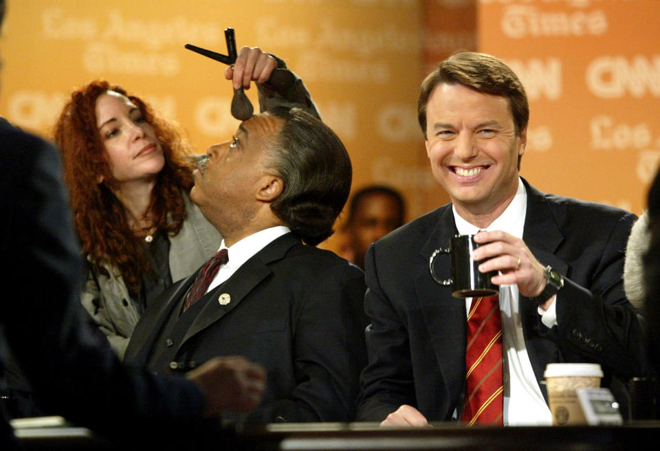 <p>U.S. Senator John Edwards (D-NC) (R) smiles as a make up artist applies make up to the face of Rev. Al Sharpton at the beginning of a debate at the University of Southern California February 26, 2004 in Los Angeles, California. Edwards, Sharpton, U.S. Senator John Kerry (D-MA) and U.S. Congressman Dennis Kucinich (D-OH) are all taking part in the debate. (Photo by Chris Hondros/Getty Images) </p>