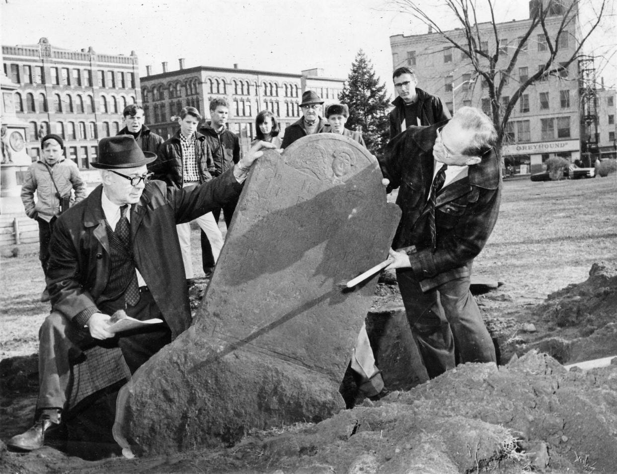 In a 1967 file photo, Charles H. Bouley, left, and Daniel A. Farber check the gravestone of Elizabeth Jennison which they uncovered in Worcester Common the previous year