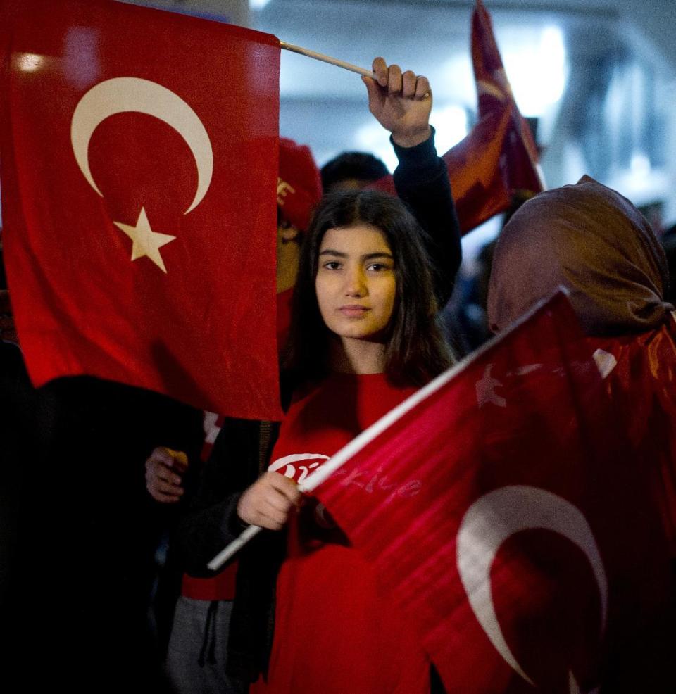 Demonstrators wave turkish flags outside the Turkish consulate in Rotterdam, Netherlands, Saturday, March 11, 2017. Turkish Foreign Minister Mevlut Cavusoglu was due to visit Rotterdam on Saturday to campaign for a referendum next month on constitutional reforms in Turkey. The Dutch government says that it withdrew the permission for Cavusoglu's plane to land because of "risks to public order and security." (AP Photo/Peter Dejong)