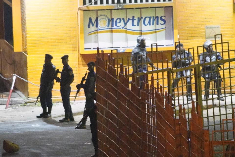 Congolese riot police take position around the electoral commission building at night in Kinshasa, Congo, Tuesday Jan. 8, 2019. As Congo anxiously awaits the outcome of the presidential election, many in the capital say they are convinced that the opposition won and that the delay in announcing results is allowing manipulation in favor of the ruling party. (AP Photo/Jerome Delay)