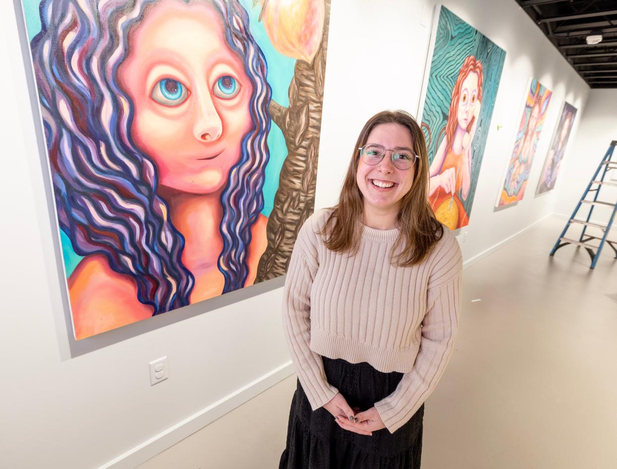 Local artist Maria McDonald poses in the Massillon Museum's Studio M with some of her artwork from her upcoming show - "In Another Life: A Tale of Love, Loss and Living." Her paintings explore the ideas of feminism, love, loss and heartache.