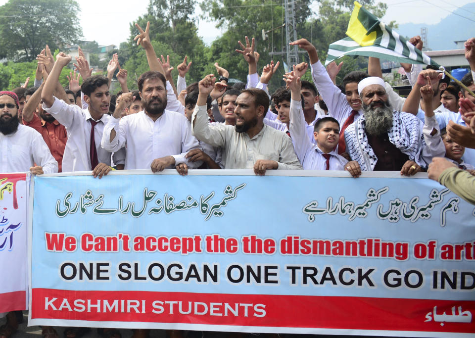 Pakistani Kashmiris attend an anti-India protest in Muzaffarabad, Pakistan, capital of Pakistani Kashmir, Friday, Aug. 9, 2019. Islamabad said it would downgrade its diplomatic ties with New Delhi, expel the Indian ambassador and suspend trade. Prime Minister Imran Khan told Pakistan's National Security Committee that his government will use all diplomatic channels "to expose the brutal Indian racist regime" and human rights violations in Kashmir, the government's statement said. The banner reads: "We are Kashmiris." (AP Photo/M.D. Mughal)