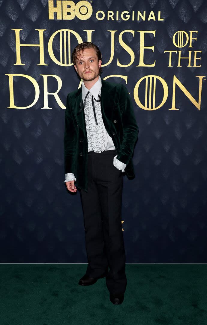 Tom Glynn-Carney, el actor y cantante británico que interpreta al príncipe Aegon Targaryen, primer hijo de Viserys I con Alicent Hightower, optó por un saco de terciopelo verde oscuro, pantalón negro y una camisa blanca con volados
