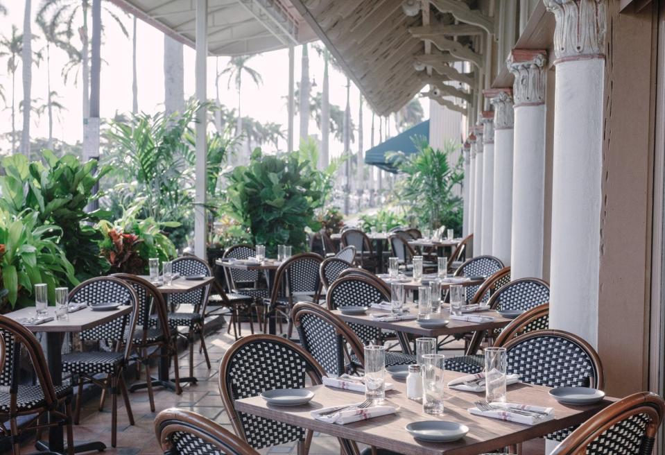 Almond's outdoor dining patio flanks Royal Poinciana Way's sidewalk in Palm Beach.