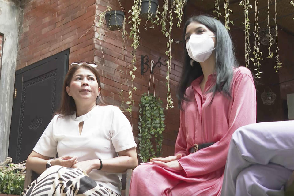 In this image made from video, contestant of Miss Universe Indonesia Priskila Ribka Jelita, center, speaks as mother, Maria Napitupulu, left, looks on during an interview with the Associated Press Television in Jakarta, Indonesia, Tuesday, Aug. 15, 2023. The lawyer of a number of contestants of Miss Universe Indonesia pageant said Tuesday they have filed complaints with police, accusing local organizers of sexual harassment. (AP Photo/APTN)