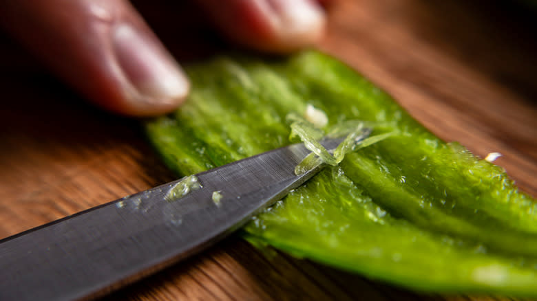 person deveining a serrano pepper