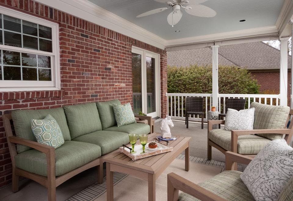 This covered brick porch and patio in Lyndon is outfitted in colors that have been pulled from other parts of the house.