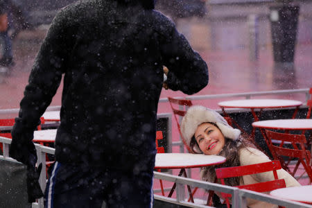 A woman poses for a friend as snow falls in the Times Square neighborhood of New York, U.S., February 12, 2019. REUTERS/Lucas Jackson