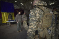 In this photo provided by the Ukrainian Presidential Press Office, Ukrainian President Volodymyr Zelenskyy, centre left, stands along servicemen during a minute of silence in honor of soldiers killed during fighting with Russian troops as he visits the Sloviansk, Donbas region, Ukraine, Tuesday, Dec. 6, 2022. (Ukrainian Presidential Press Office via AP)