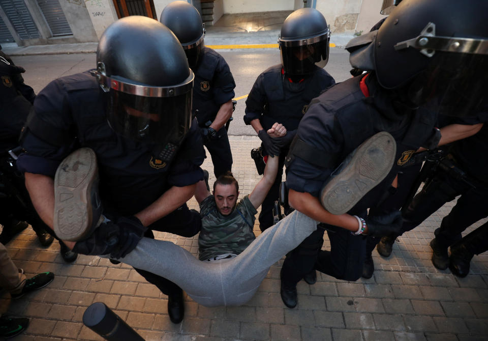 <p>Catalan police officers remove a protestor from the street outside a Unipost office which was raided in search of material for the proposed October 1 referendum, in Terrassa, Spain, Sept. 19, 2017. (Photo: Albert Gea/Reuters) </p>