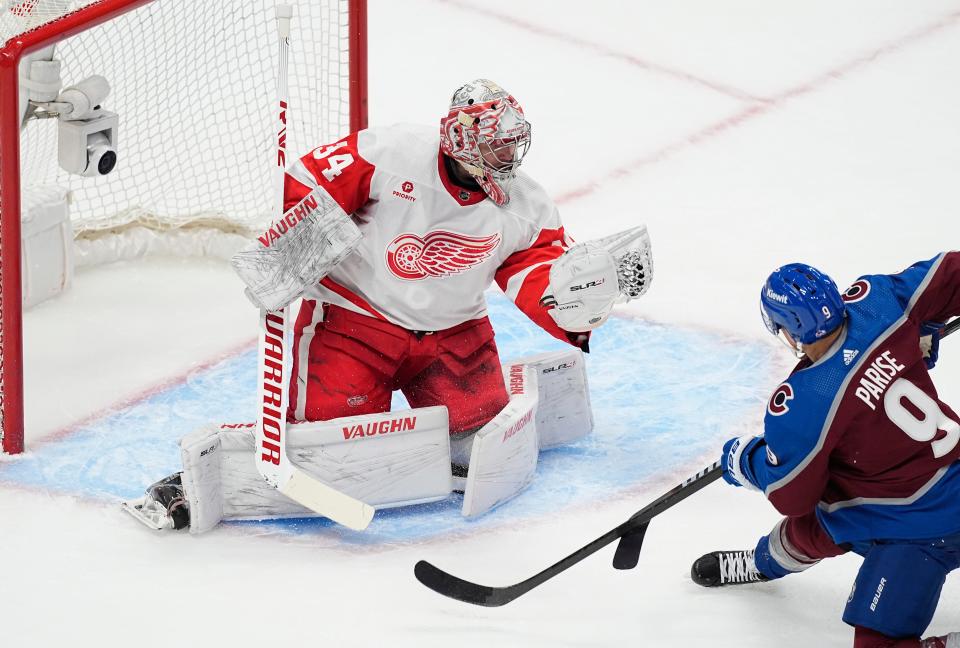 Red Wings goaltender Alex Lyon, left, makes a glove save of a shot by Avalanche left wing Zach Parise during the first period on Wednesday, March 6, 2024, in Denver.