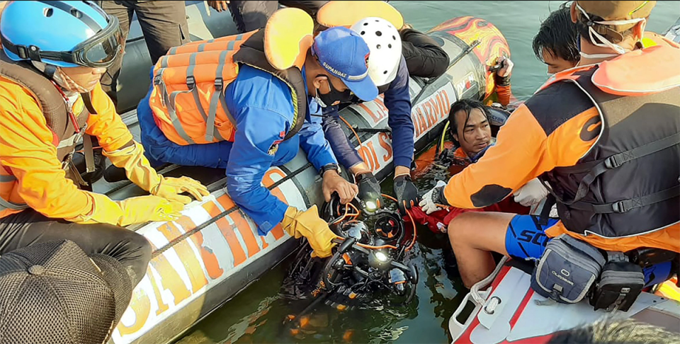 Rescuers recover items from the water.