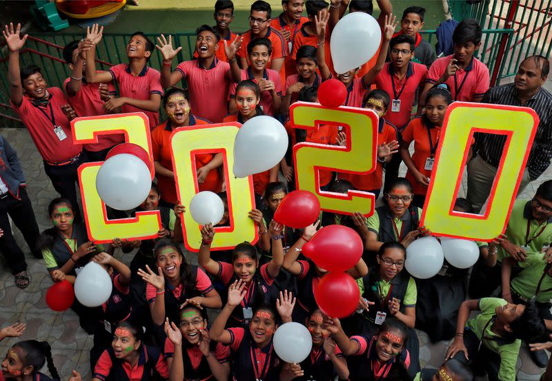 Students cheer as they release balloons during celebrations to welcome the New Year at a school in Ahmedabad