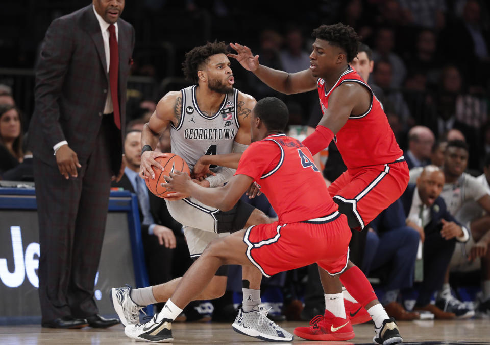 St. John's guard Greg Williams Jr., middle, and forward Marcellus Earlington (10) defend against Georgetown guard Jagan Mosely, left, during the second half of an NCAA college basketball game in the first round of the Big East men's tournament Wednesday, March 11, 2020, in New York. (AP Photo/Kathy Willens)