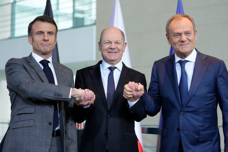 El canciller alemán, Olaf Scholz; el presidente francés, Emmanuel Macron, y el primer ministro de Polonia, Donald Tusk, se estrechan las manos en una conferencia de prensa en Berlín, Alemania, el viernes 15 de marzo de 2024. (AP Foto/Ebrahim Noroozi)