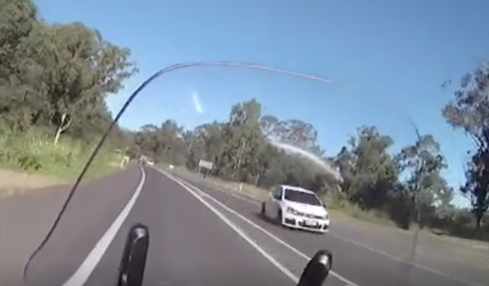 The speeding white Volkswagon Golf passes the lone officer in Gympie, Queensland.