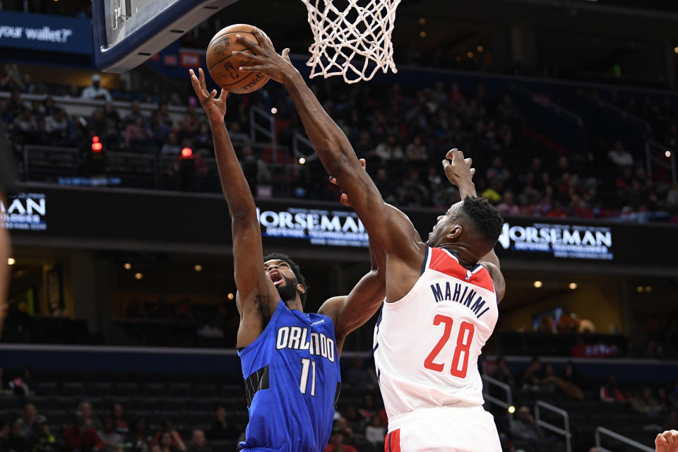 Orlando Magic forward Amile Jefferson (11) goes to the basket next to Washington Wizards center Ian Mahinmi (28) during the first half of an NBA basketball game Wednesday, Jan. 1, 2020, in Washington. (AP Photo/Nick Wass)