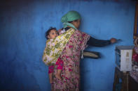 In this in Wednesday, March 25, 2020 photo, a woman bakes bread for her family in an overcrowded housing complex in Sale, near Rabat, Morocco. (AP Photo/Mosa'ab Elshamy)