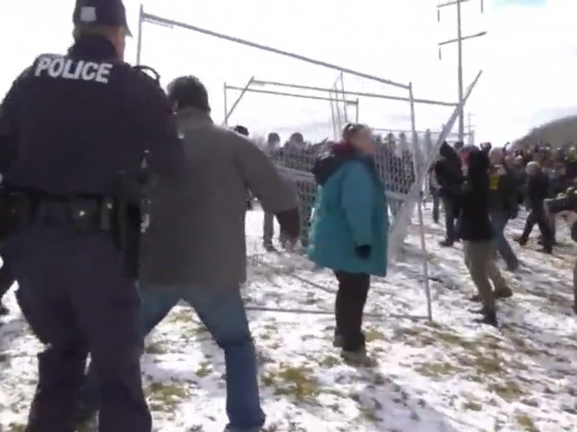 <p>Police attempt to put fences back up taken down by protesters in Edmonton, Alberta, Sunday 11 April 2021</p> ((CTV News))