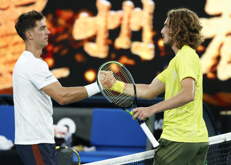 Greece's Stefanos Tsitsipas, right, is congratulated by Australia's Thanais Kokkinakis after winning their second round match at the Australian Open tennis championship in Melbourne, Australia, Thursday, Feb. 11, 2021.(AP Photo/Rick Rycroft)