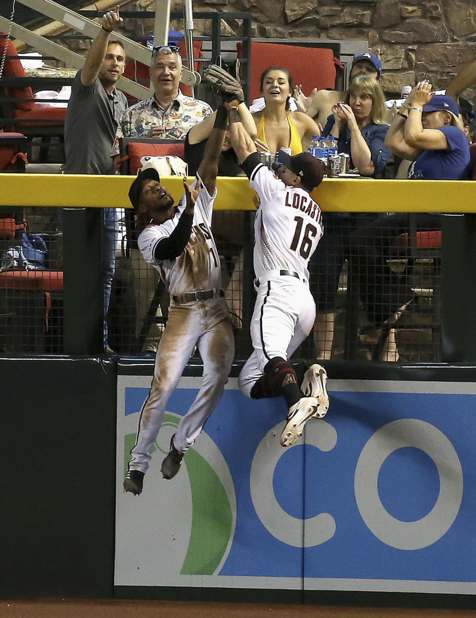 Arizona Diamondbacks center fielder Jarrod Dyson, left, makes a catch taking a home run away from Los Angeles Dodgers' Joc Pederson as Dyson collides with Diamondbacks right fielder Tim Locastro (16) during the seventh inning of a baseball game Wednesday, June 26, 2019, in Phoenix. (AP Photo/Ross D. Franklin)