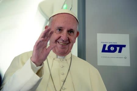 Pope Francis waves during a press conference on the plane after his visit to Krakow, Poland for the World Youth Days, on July 31, 2016. REUTERS/Filippo Monteforte/Pool