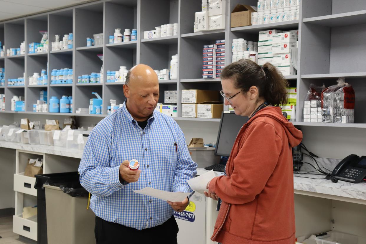 Beacon Charitable Pharmacy workers discuss a prescription.