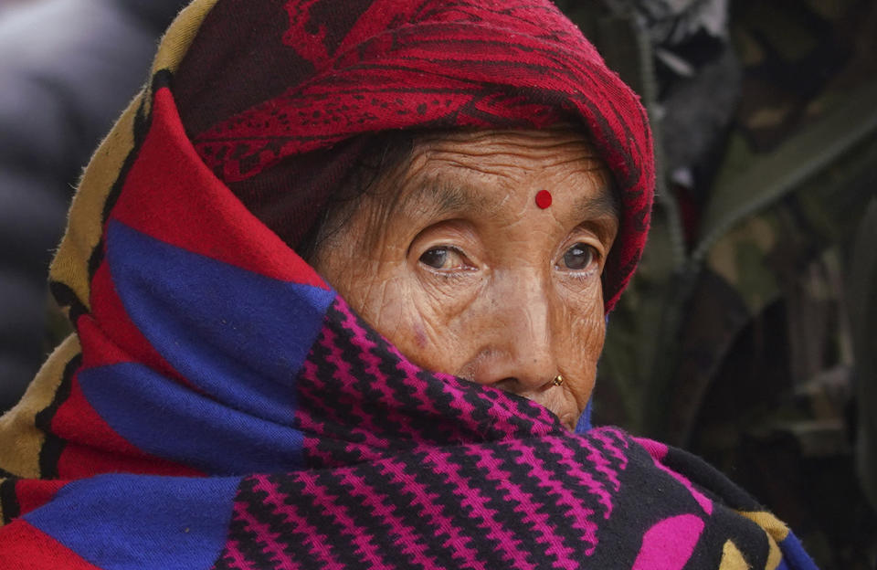 An elderly woman waits outside a hospital where bodies of victims of a plane crash are being kept in Pokhara, Nepal, Monday, Jan 16, 2023. Nepal began a national day of mourning Monday as rescue workers resumed the search for six missing people a day after a plane to a tourist town crashed into a gorge while attempting to land at a newly opened airport, killing at least 66 of the 72 people aboard in the country's deadliest airplane accident in three decades. (AP Photo/Yunish Gurung)