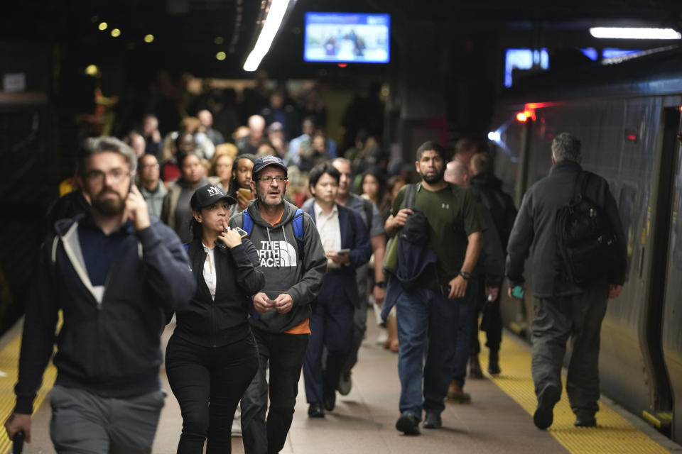 Commuters walk along the track to board a train on the Hudson line at Grand Central Terminal following heavy rain, Friday, Sept. 29, 2023, in New York. (AP Photo/Mary Altaffer)