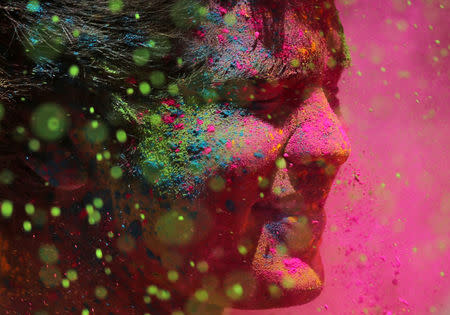 A man daubed in colours reacts as colour powder is thrown towards him during Holi celebrations in Mumbai, India, March 21, 2019. REUTERS/Francis Mascarenhas