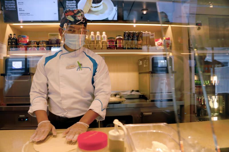 A member of the staff wears a mask and a face shield to prevent the spread of the coronavirus disease (COVID-19), at the canteen on the Explorer Dream cruise ship, in Keelung