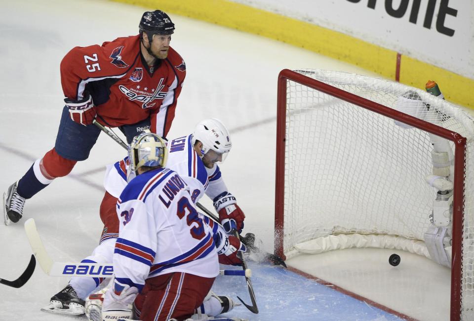 Washington Capitals left wing Jason Chimera (25) scores a goal against New York Rangers goalie Henrik Lundqvist (30), from Sweden, and Kevin Klein (8) during the second period of Game 6 in the second round of the NHL Stanley Cup hockey playoffs, Sunday, May 10, 2015, in Washington. (AP Photo/Nick Wass)