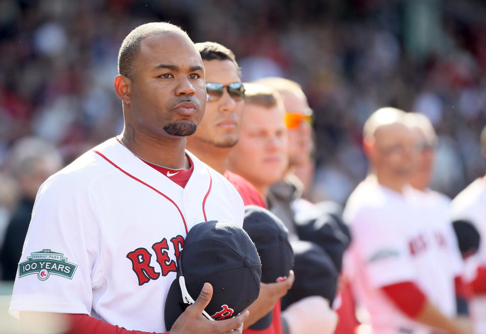 Carl Crawford #13 of the Boston Red Sox and the rest of his teammates stand in the seventh inning stretch against the Tampa Bay Rays during the home opener on April 13, 2012 at Fenway Park in Boston, Massachusetts. (Photo by Elsa/Getty Images)