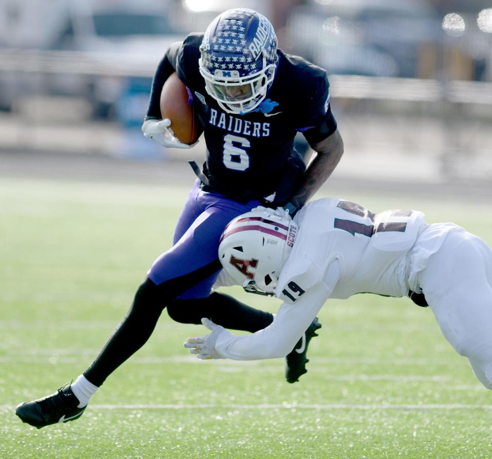 Mount Union wide receiver Wayne Ruby runs the ball for a first down under pressure from Alma defensive back Anthony Spears in the second quarter of NCAA Division III playoff at Mount Union. Saturday, November 25, 2023.