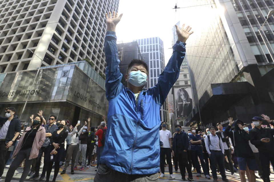 A demonstrator raises his hands during a protest in the financial district in Hong Kong, Friday, Nov. 15, 2019. Protesters who have barricaded themselves in a Hong Kong university partially cleared a road they were blocking and demanded that the government commit to holding local elections on Nov. 24. (AP Photo/Achmad Ibrahim)