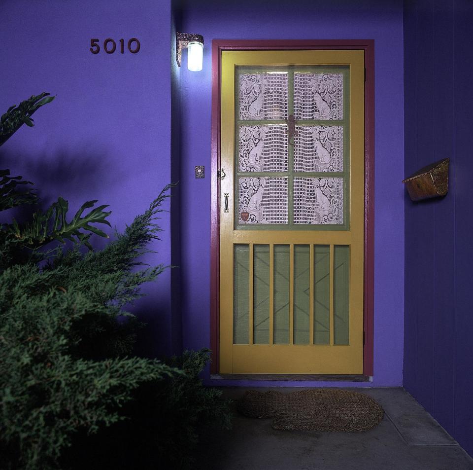 This undated photo released courtesy Bob Walker shows the outside of their house painted a brightly colored hue at the home in San Diego, Calif. Bob Walker and Frances Mooney moved into the house in 1986 and started converting it into a human-sized cat condo with 140 feet of elevated highway, tunnels, ramps, a spiral staircase, rest areas and scenic vistas. It even had a floor to ceiling scratching post. One improvement seemed to lead to another. (AP Photo/Courtesy Bob Walker)