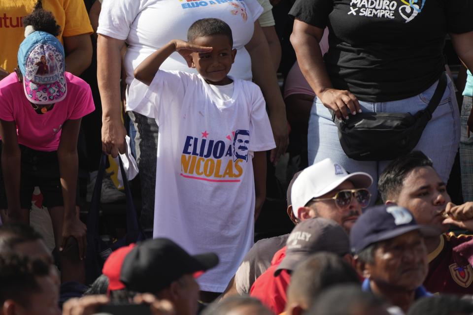 Un niño, vestido con una camiseta a favor del presidente de Venezuela, Nicolás Maduro, saluda durante un mitin en el vecindario de Petare, en Caracas, Venezuela, el 18 de julio de 2024. Venezuela celebrará elecciones presidenciales el 28 de julio. (AP Foto/Ariana Cubillos)