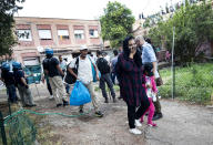 Police evict people from an abandoned school which they had occupied on the outskirts of Rome, Monday, July 15, 2019. Police are evicting migrants and Italians from an abandoned former school on Rome's outskirts in the latest operation to empty occupied buildings of migrants and squatters. (Massimo Percossi/ANSA via AP)