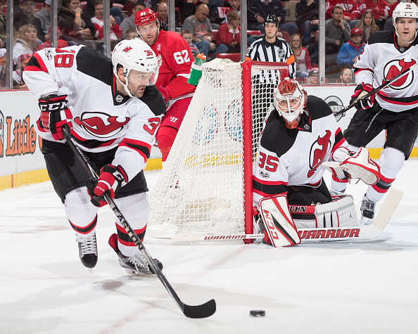 DETROIT, MI - JANUARY 31: Vernon Fiddler #38 of the New Jersey Devils skates around the net with the puck in front of Thomas Vanek #62 of the Detroit Red Wings during an NHL game at Joe Louis Arena on January 31, 2017 in Detroit, Michigan. The Devils defeated the Wings 4-3. (Photo by Dave Reginek/NHLI via Getty Images)