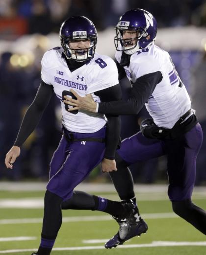 Northwestern kicker Jack Mitchell (8) celebrates with quarterback Christian Salem (18) after a field goal against Notre Dame in overtime of an NCAA college football game in South Bend, Ind., Saturday, Nov. 15, 2014. Northwestern won 43-40. (AP Photo/Nam Y. Huh)