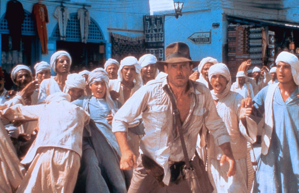 5: Eine der Szenen aus Steven Spielbergs “Raiders of the Lost Ark” (“Jäger des verlorenen Schatzes”), die den schlagfertigen Charakter der Hauptfigur am besten beschreibt, war purer Zufall. Harrison Ford sollte sich als Indiana Jones einen ausgeklügelten Kampf mit einem Schwertkämpfer liefern. Ausgerechnet am Drehtag war Ford krank und konnte die Szene nicht drehen. Stattdessen schlug er Spielberg vor: “Erschießen wir den Kerl doch einfach.” Statt sich im fertigen Film auf die rituelle Eröffnung des Schwertkämpfers einzulassen, knallt Indiana Jones ihn einfach über den Haufen. (Bild-Copyright: ddp images)
