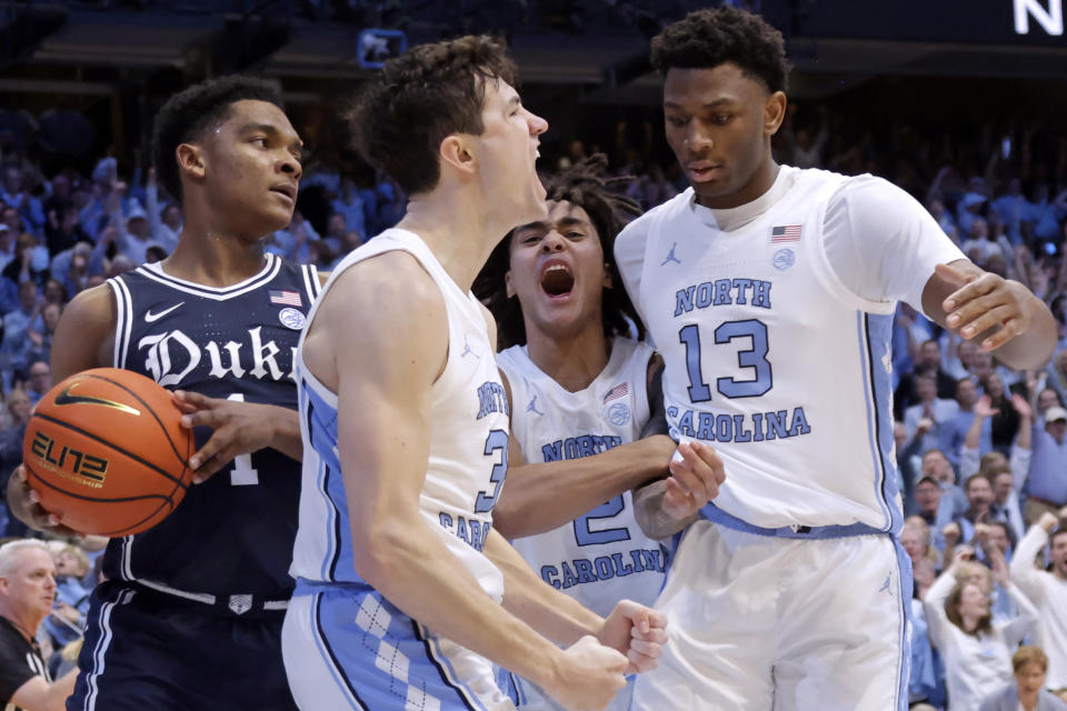 North Carolina guard Cormac Ryan (3) celebrates with guard Elliot Cadeau (2) and forward Jalen Washington (13) while Duke guard Caleb Foster (1) looks on during the first half of an NCAA college basketball game Saturday, Feb. 3, 2024, in Chapel Hill, N.C. (AP Photo/Chris Seward)