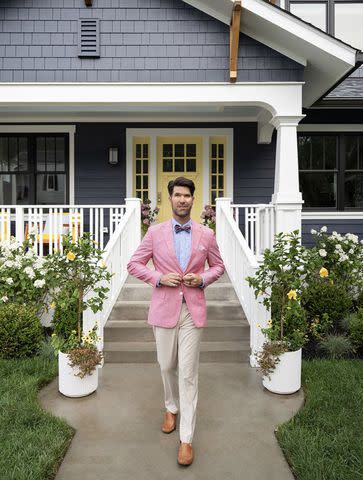 <p>HGTV</p> Brian Patrick Flynn posing in front of the home's bright yellow door