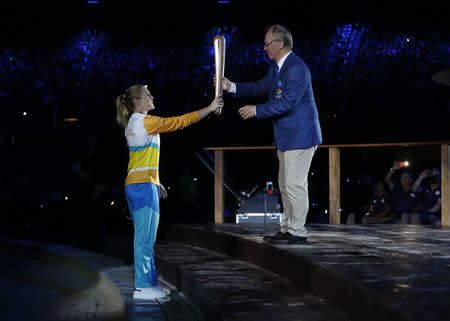 Gold Coast 2018 Commonwealth Games - Opening ceremony - Carrara Stadium - Gold Coast, Australia - April 4, 2018 - Sally Pearson passes the baton to Britain’s Prince Charles during the opening ceremony. REUTERS/Paul Childs