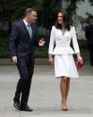 <p>Kate landete in einem weißen Mantelkleid von Alexander McQueen für einen Besuch in Polen. Wildleder-Heels von Gianvito Rossi zierten ihre Füße und eine Clutch in der polnischen Nationalfarbe Rot rundeten den eleganten Look ab. (Bild: PA) </p>