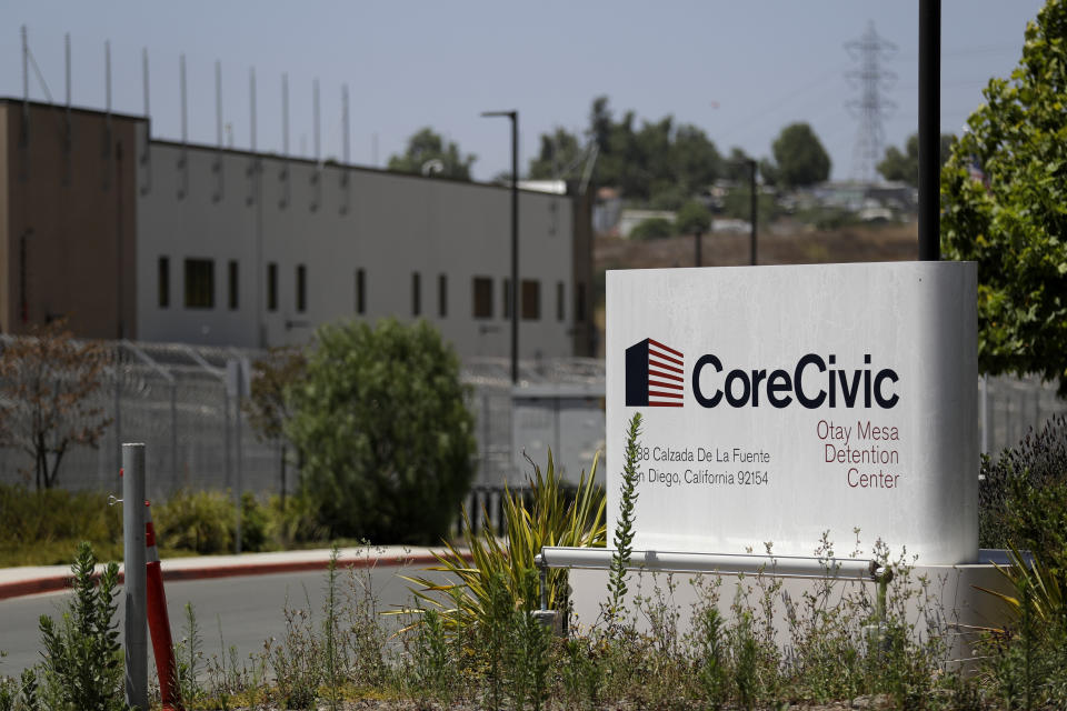 A sign for the Otay Mesa Detention Center sits in front of the building Tuesday, July 7, 2020, in San Diego. The early absence of facial coverings, lack of cleaning supplies and mixing symptomatic detainees with others preceded the first big outbreak at U.S. Immigration and Customs Enforcement's 221 detention centers. While the point of origin is unclear, accounts of how the virus spread at the Otay Mesa Detention Center expose shortcomings and inherent difficulties of managing the world's largest immigration detention system during a pandemic. (AP Photo/Gregory Bull)