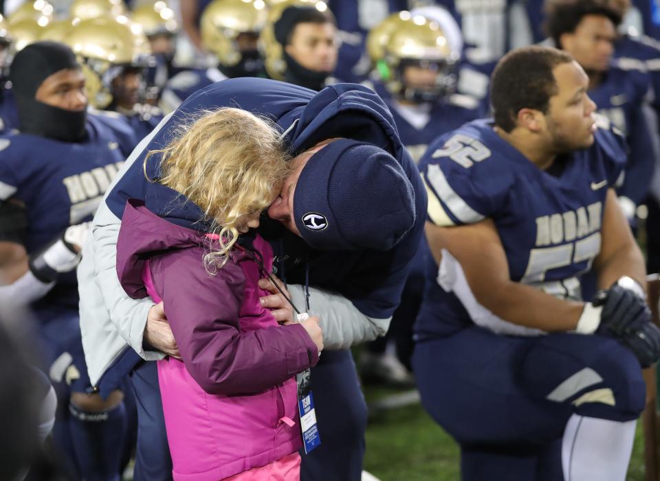 Hoban football coach Tim Tyrrell hugs his daughter after the OHSAA Division II State Championship football game at Tom Benson Hall of Fame Stadium, Thursday, Dec. 1, 2022, in Canton, Ohio.