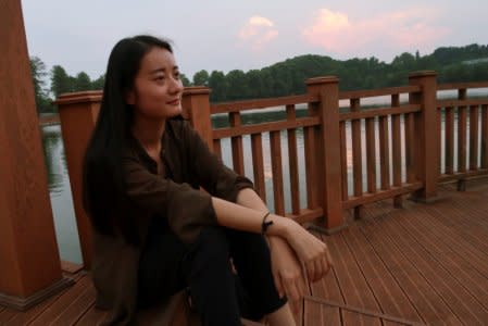 Qi Jing, a township-level Communist Youth League leader, poses for pictures by a lake in Wuhan, Hubei province, China, September 26, 2017.  REUTERS/John Ruwitch