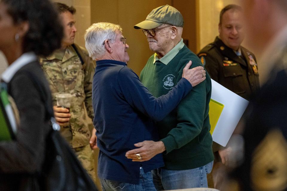 Retired Army Col. Paris Davis, an Ohio native, who is set to receive the Medal of Honor for his service in the Vietnam War, hugs his friend Jim Moriarty before sitting down for an interview with the Associated Press at a hotel in Arlington, Va., Thursday, March 2, 2023. (AP Photo/Andrew Harnik)