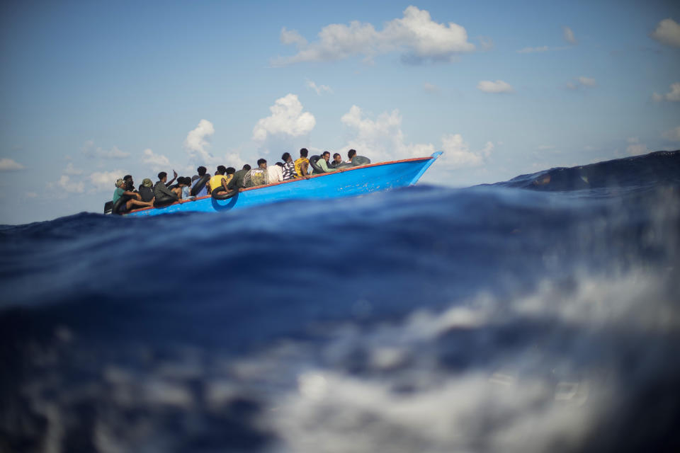 Migrantes en un bote de madera navegan por el Mar Mediterráneo el 11 de agosto de 2022, al sur de la isla italiana de Lampedusa. (AP Foto/Francisco Seco)